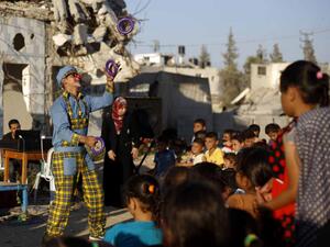 A clown entertains children in a destroyed neighborhood of Gaza City on July 8, 2015.  (AFP/Mohammed Abed)