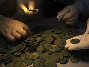 Experts look closely at the Roman coins. (AFP/ File Photo)