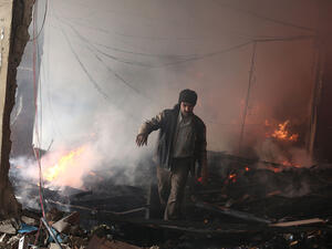 A man walks amid debris inside a heavily damaged building following reported air strikes by regime forces in Douma on 9 February, 2015. (AFP/Abd Doumany)
