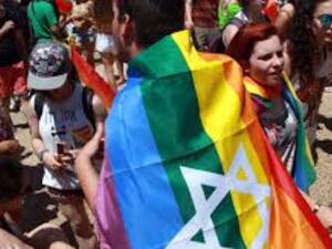 An Israeli with a rainbow-colored flag draped around his shoulders attends the annual gay pride parade in the Israeli coastal city of Tel Aviv on June 12, 2015. (AFP/Gil Cohen-Magen)