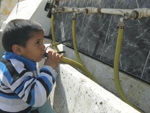 A boy takes a drink from emergency water supplies being distributed by the UN. (AFP/File)