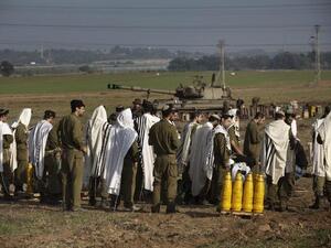 جنود اسرائيليون يؤدون صلاة صباحية/الاربعاء/على مشارف غزة/أ.ف.ب
