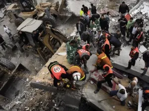 عمال انقاذ ومسعفون يحاولون اخراج جرحى وشهداء من تحت انقاض مبنى دمره القصف/أ.ف.ب