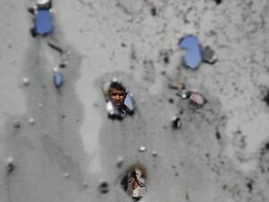 فلسطيني ينظر من خلال الحفر التي احدثتها غارة جوية اسرائيلية في جدران منزله في مخيم جباليا للاجئين الفلسطينيين في غزة/أ.ف.ب