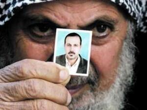 والد المبحوح يحمل صورة له