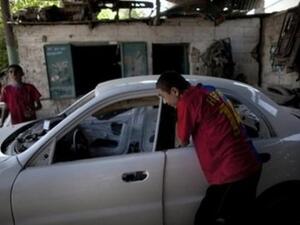 شابان فلسطينيان يعملان في ورشة لتصليح السيارات في غزة