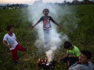 Refugee children play around a makeshift fire at a camp on the Greece-Macedonia border.  (AFP/Bulent Kilic)