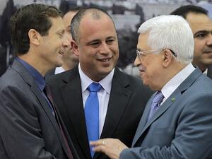 زعيم المعارضة الاسرائيلية اسحق هرتسوغ (يسار) مصافحا الرئيس الفلسطيني محمود عباس خلال لقاء سابق بينهما