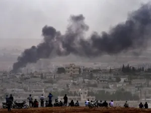 Kurdish people look at the Syrian town of Kobani from the Turkish side of the border. (AFP/Aris Messinis)