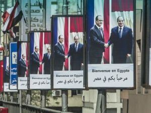 A picture taken from behind a windshield shows Egyptians driving past posters of President Abdel Fattah al-Sisi (R) and his French counterpart Francois Hollande displayed on Cairo's Six October bridge on April 17, 2016, ahead of the visit of the French president in the capital. (AFP/File)
