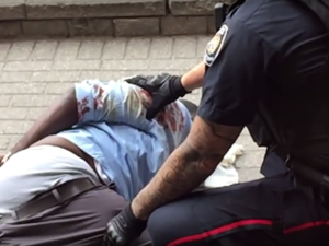 A screenshot from a video uploaded to YouTube shows Abdirahman Abdi on the ground in Ottawa after a violent arrest by police. (YouTube/Islam Muslim) 