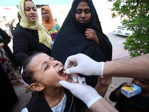 An internally displaced Iraqi girl receives a dose of cholera vaccine at a camp for internally displaced in southwest of the oil hub of Basra on November 1, 2015. (AFP/Haidar Mohammed)