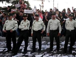 Iranian policemen stand guard as supporters of Iranian moderate presidential candidate, Hassan Rowhani, attend a street rally at Vanak square in northern Tehran on June 12 (Behrouz Mehri / AFP)
