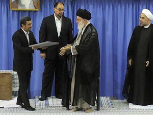 IRAN, Tehran : A handout picture released by the official website of the Iranian supreme leader Ayatollah Ali Khamenei on August 3, 2013, shows Khamenei is given the officially endorsment papers from former president Mahmoud Ahmadinejad as moderate cleric Hassan Rowhani looks on during a ceremony in the capital Tehran.  AFP PHOTO / HO / KHAMENEI.IR