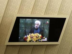 IRAN, Tehran : Iranian President Hassan Rowhani is seen on a TV screen as he speaks during a parliament session to elect the cabinet members on August 15, 2013. AFP PHOTO/BEHROUZ MEHRI