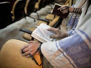 Iranian Jewish men, reading from the Torah, pray at a synagogue in Tehran on September 30, 2013.  (AFP/Behrouz Mehri)