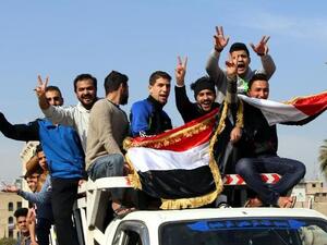 Men in Baghdad celebrate the Iraqi National Football Team's defeat of Iran in the 2015 Asian Cup on January 23, 2015.  (AFP/Ali al-Saadi)