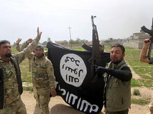 Members of the Iraqi paramilitary Popular Mobilization Forces celebrate with a Daesh flag after retaking the village of Albu Ajil near Tikrit in March 2015. (AFP/Ahmad al-Rubaye)
