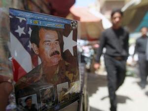 A man holds a CD with a photo of former Iraq President Saddam Hussein (AFP/Ahmad Al Rubaye)