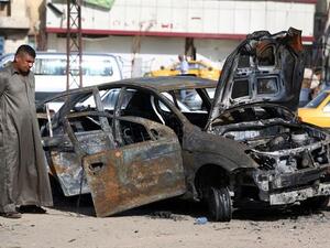 An Iraqi man inspects a burnt-out vehicle at the site of a car bomb explosion in the Hurriyah area of eastern Baghdad (Ahmad Al-Rubaye / AFP)