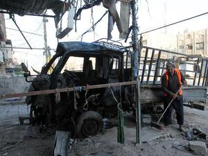 RAQ, Baghdad : An Iraqi worker cleans the pavement on August 11, 2013 on the scene of a car bomb attack that occured the day before in the northern Baghdad neighbourhood of Shaab. AFP PHOTO ALI AL-SAADI