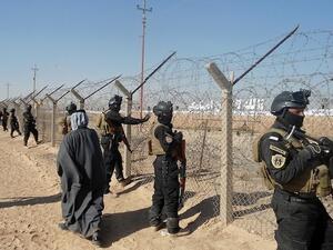 Iraqi SWAT forces stand guard outside Camp Ashraf, home to exiled Iranian opposition members. [AFP]