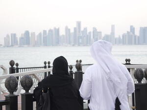 A Qatari man and woman look out at the Doha skyline. (Albawaba/ J. Zach Hollo)