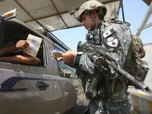 جندي عراقي يوزع دعوات للمواطنين للتعاون مع الاجهزة الامنية على احد الحواجز ببغداد/أ.ف.ب