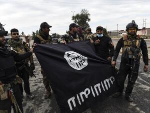 جنود من الجيش العراقي يحملون علما بطريقة "مقلوبة" لداعش بالقرب من الموصل