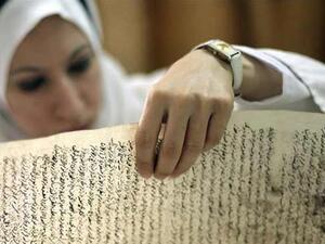 موظفة عراقية تتفقد مخطوطا عثر عليه في متحف بغداد بعد الغزو