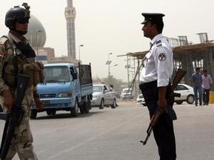 جندي وشرطي عراقيان ينظمان حركة المرور بوسط بغداد/أ.ف.ب