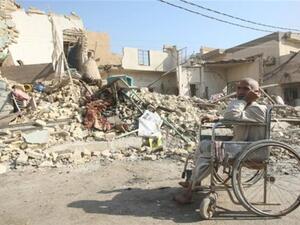 رجل عراقي مقعد الى جوار بيته المهدم/أ.ف.ب