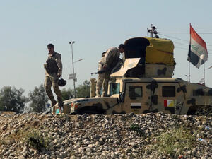 Iraqi soldiers stand near their vehicle during their withdrawal from the neighborhood of the northern Iraqi city of Kirkuk on April 27, 2013. (AFP/Marwan Ibrahim)