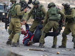 Israely soldiers detain a wounded Palestinian stone thrower during clashes in Beit El, on the 17 October 2015. (AFP /Abbas Momani)