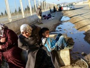 Two Syrian women and a boy wait in front of Oncupinar crossing gate, near the town of Kilis, to return to Syria on February 9, 2016. (AFP file)