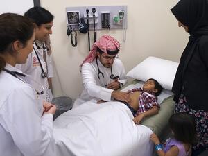 الطالب ناصر بن مرزوق خلال إجراء فحص لأحد الأطفال المشاركين في فعالية نجوم كورنيل.