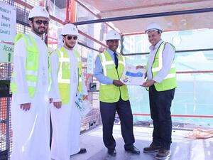 فريق إدارة البيئة والصحة والسلامة خلال توزيعهم انشرات التوعوية على العمل.