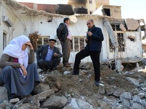 People gather among the rubble of damaged buildings following heavy fighting between government troops and Kurdish fighters in the town of Cizre in southeastern Turkey, near the border with Syria and Iraq, on March 2, 2016. (AFP/Ilyas Akengin)