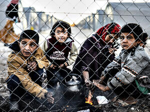A Syrian Kurdish woman and her children wait in a refugee camp in Turkey. (AFP/Bulent Kilic)