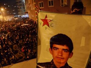 A Kurdish youth holds a picture of a YPG fighter killed in Kobane during a celebration in Diyarbakir on Jan. 26, 2015. (AFP/File)