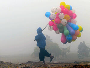 A balloon vendor walks through the fog in Lahore, Pakistan.  (AFP/Arif Ali)