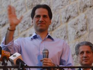 Lebanese MP Samy Gemayel waves to the crowd as his father, former president Amine Gemayel, stands behind him during celebrations by supporters of his party in the mountain resort of Bikfaya on June 8, 2009. (AFP/Joseph Barrak)