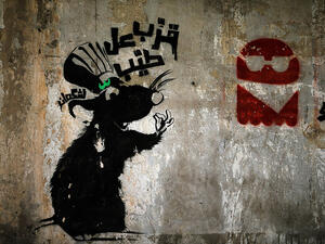 A rat beckons viewers to "come taste the goodies" above a pile of trash in Beirut, amidst Lebanon's garbage crisis.  (AFP/Joseph Eid)