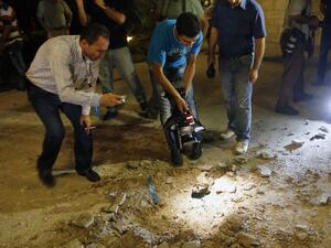 LEBANON, BAABDA : Lebanese people and journalists inspect the damage at a private residence where one of two rockets fired from an unknown location exploded in the early hours of August 2, 2013, just metres from an entrance to the presidential palace in Baabda, around eight kilometres southeast of the Lebanese capital Beirut.  AFP PHOTO / ANWAR AMRO
