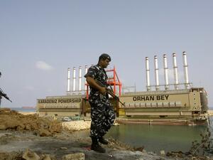 LEBANON, JIYEH : Lebanese police officers guard Turkish local power generating ship Orhan Bey docked in Jiyeh, south of Beirut, on August 13, 2013. AFP PHOTO/MAHMOUD ZAYYAT