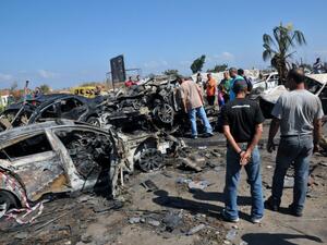 LEBANON, Tripoli : Lebanese look at burnt vehicles on August 24, 2013 on the site of a bombing outside Al-Taqwa mosque the day before in the northern city of Tripoli. AFP PHOTO IBRAHIM CHALHOUB