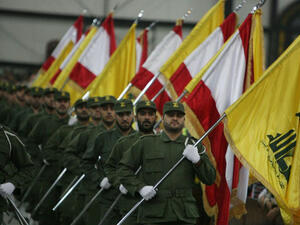  Hezbollah fighters, holding up Lebanese flags and the yellow flag of the militant Shiite Muslim group. AFP PHOTO/RAMZI HAIDAR