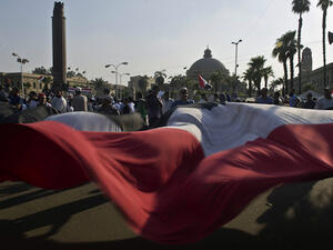 Egyptian supporters of President Mohamed Morsi wave a large national flag during a rally outside Cairo University (Source: AFP/KHALED DESOUKI)