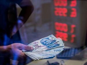 A teller holds Turkish lira banknotes at a currency exchange office in Istanbul. Photograph: Yasin Akgul/AFP/Getty Images