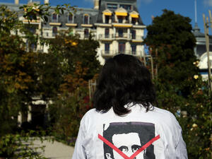 متظاهر يقف امام مقر الاجتماع في لوزان 